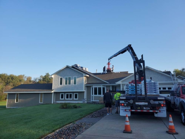 Roofing materials being delivered to home.